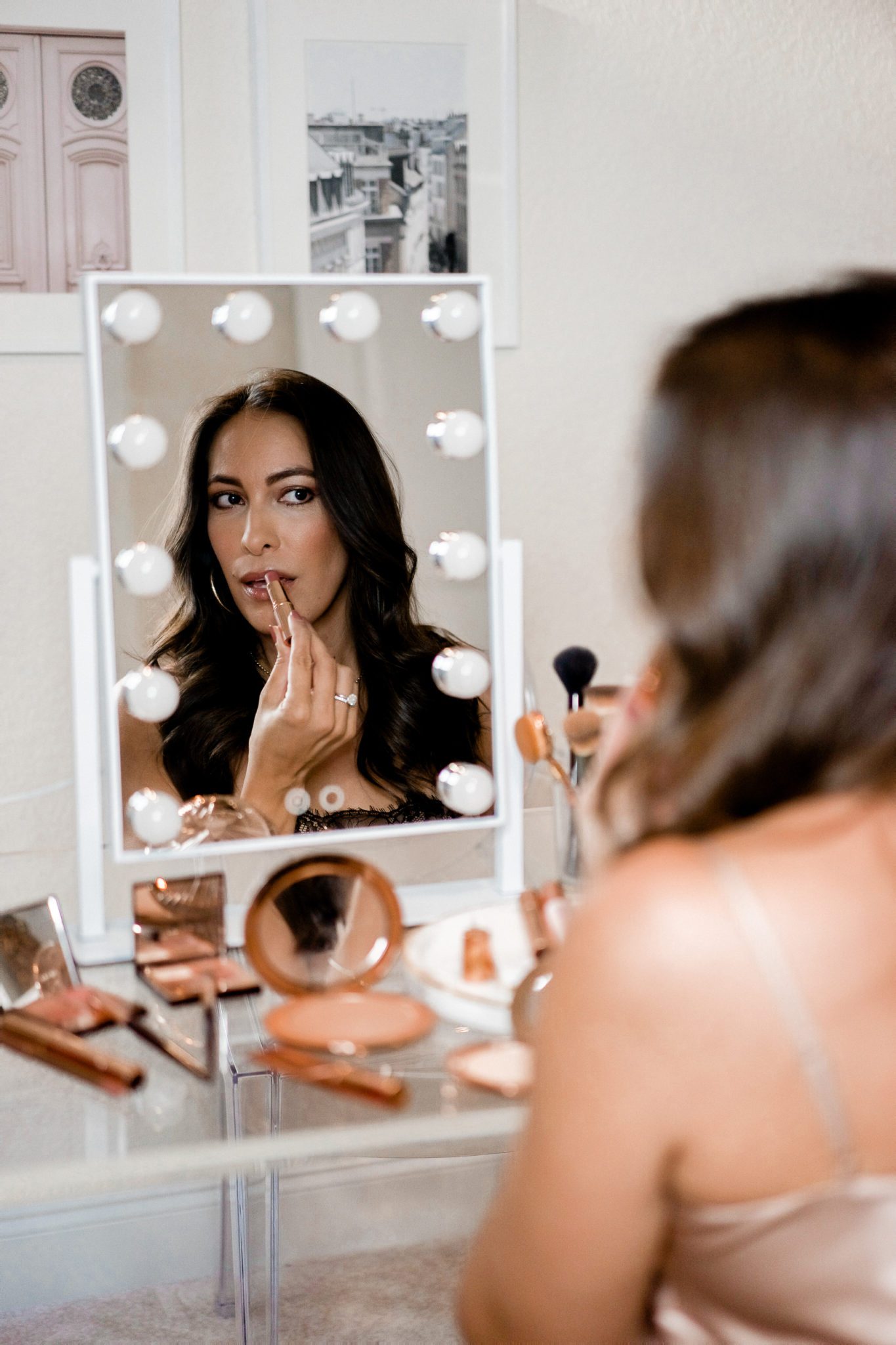 Charlotte Tilbury Favorites: 7 Fall Beauty Essentials by popular Florida beauty blog, A Glam Lifestyle: image of a woman sitting in front of a makeup mirror and applying Charlotte Tilbury makeup. 